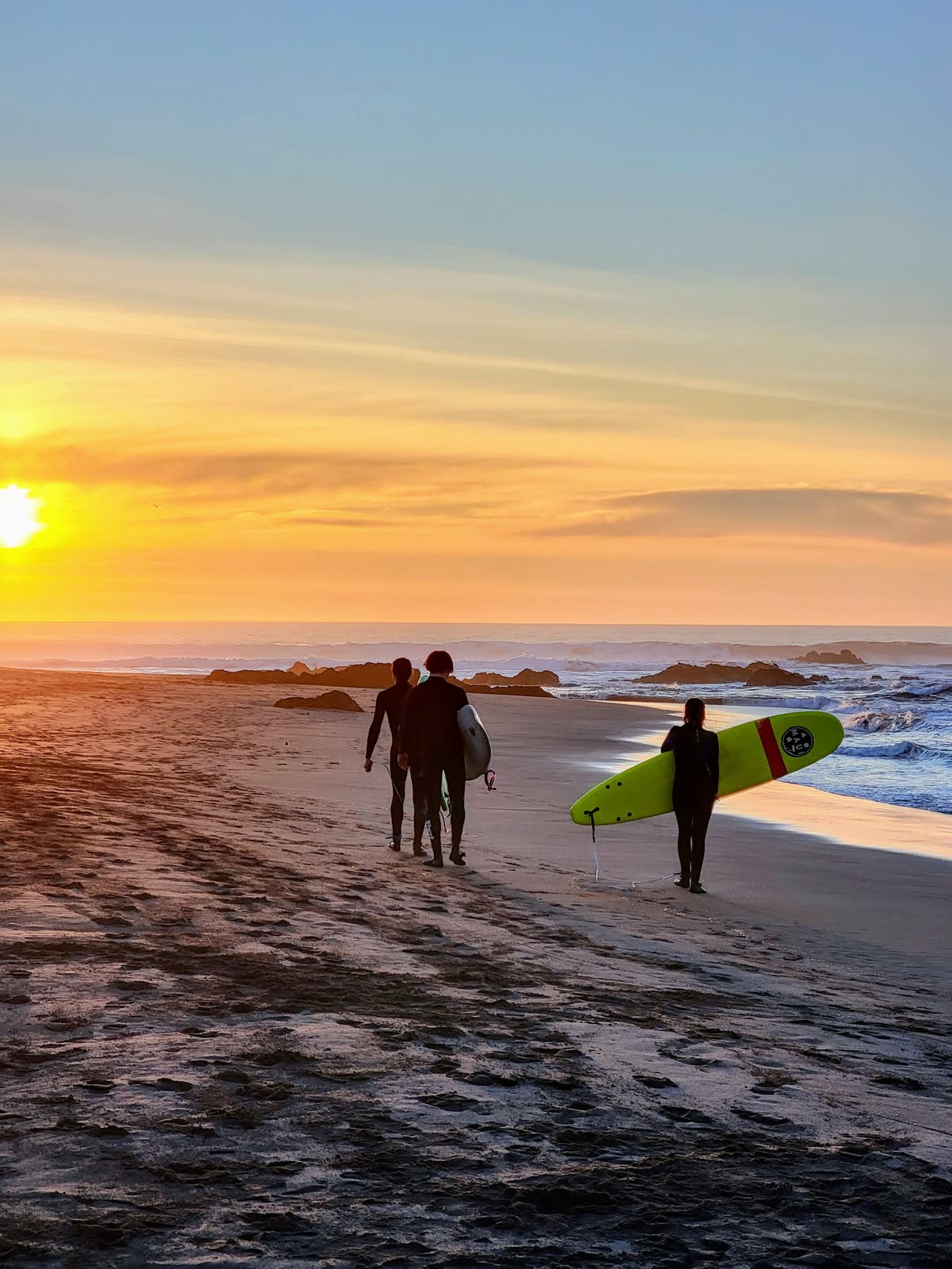 Atardecer sobre el mar en Pichilemu con surfistas en el agua