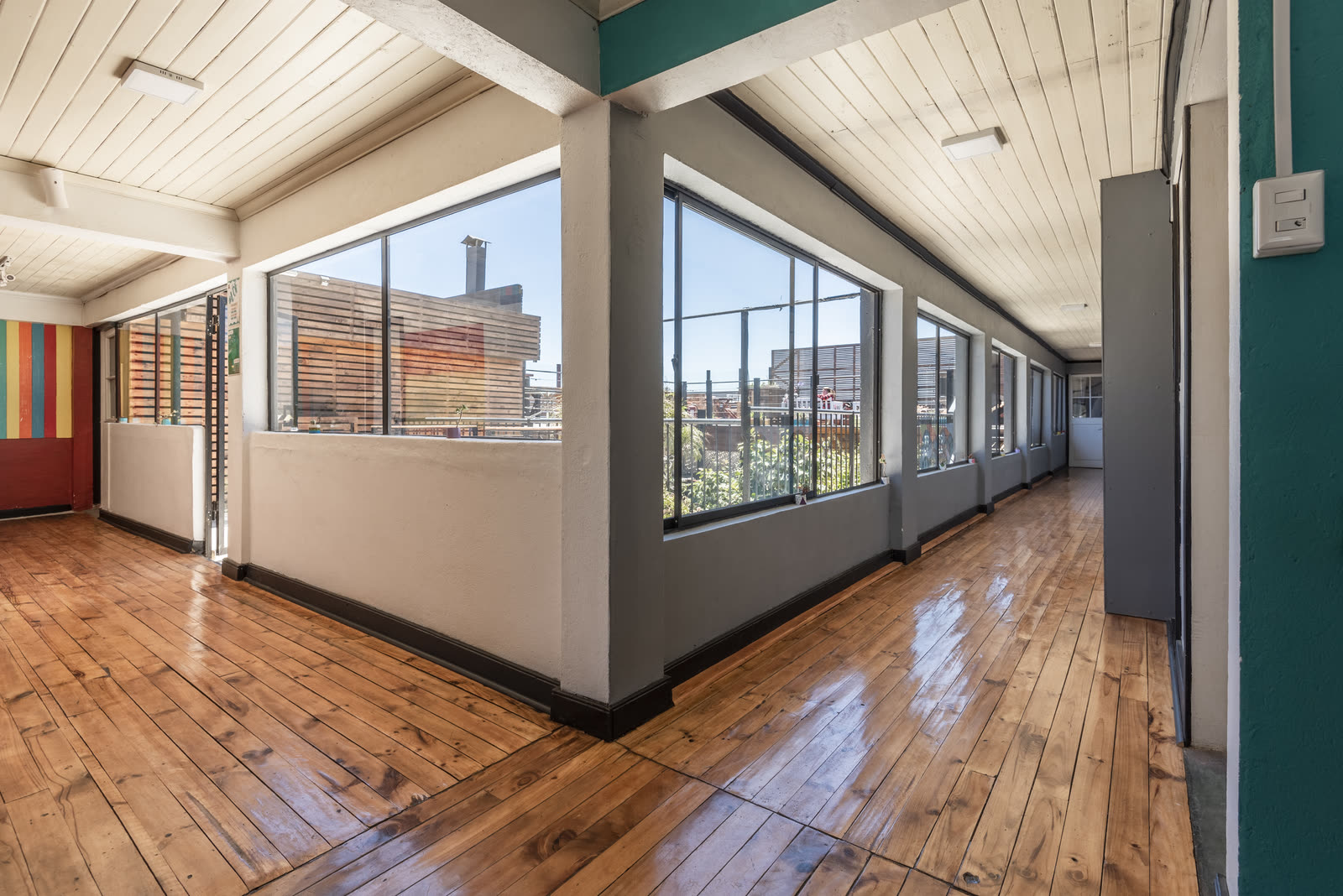 Galería con ventanales de piso a techo y piso de madera